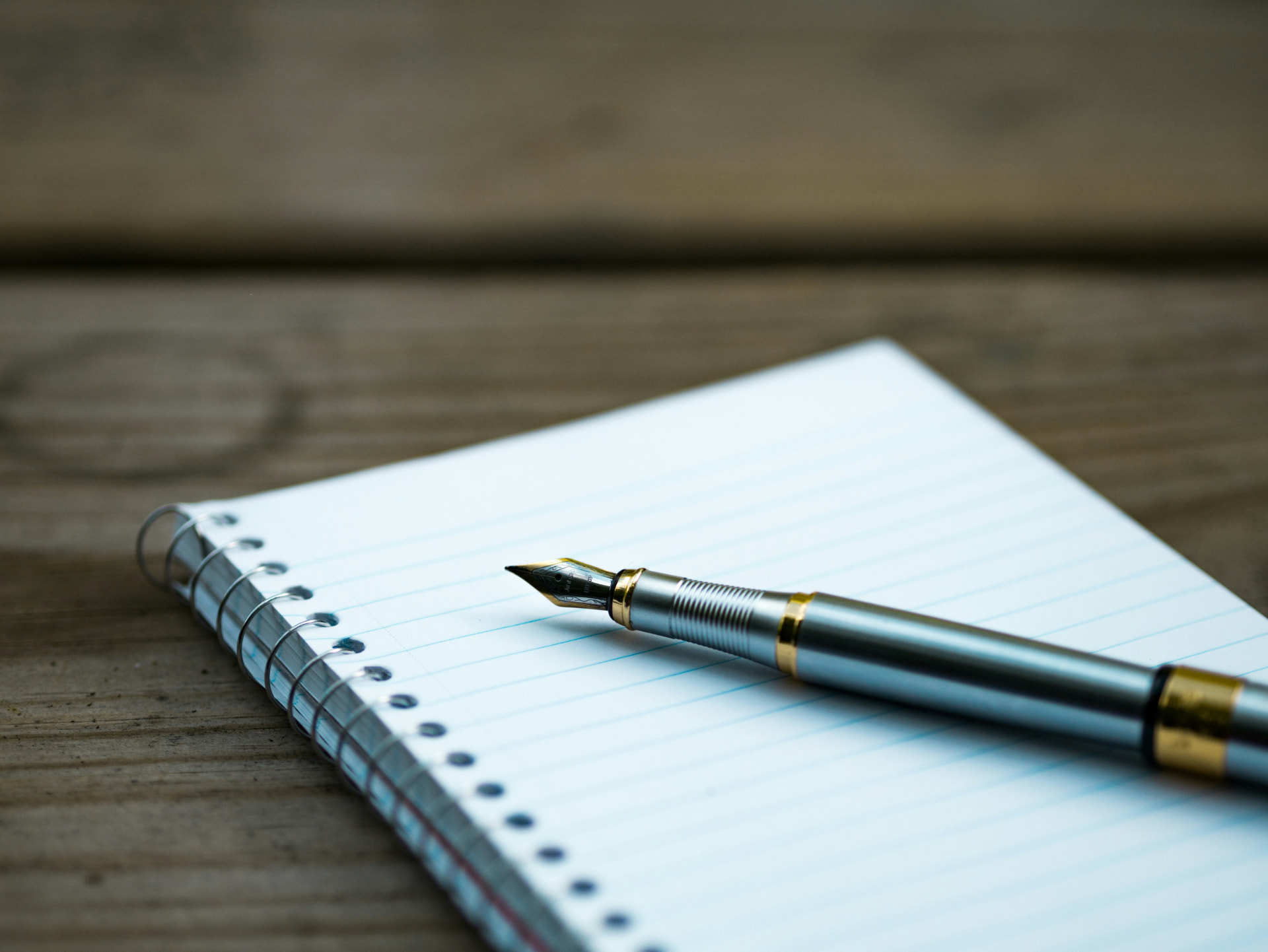 A fountain pen resting on a notebook